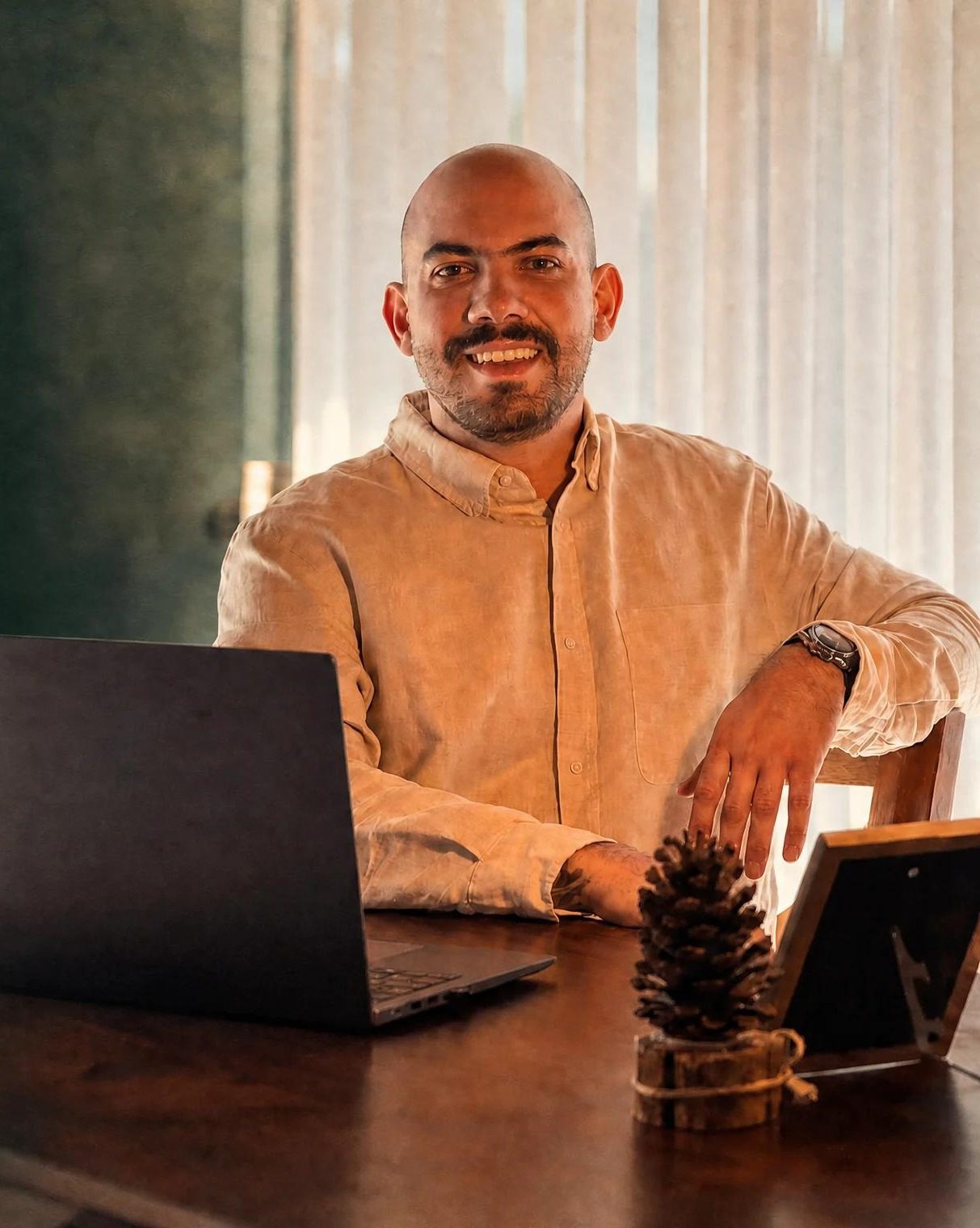 Eid Kamel El Ghoz Neto sentado à mesa, com notebook
