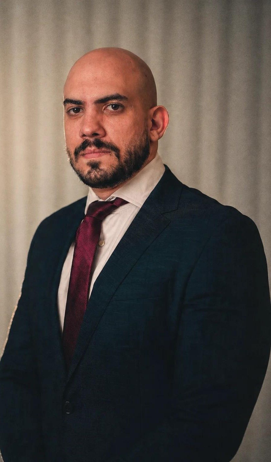 Retrato de Eid Kamel El Ghoz Neto, de terno escuro e gravata vinho